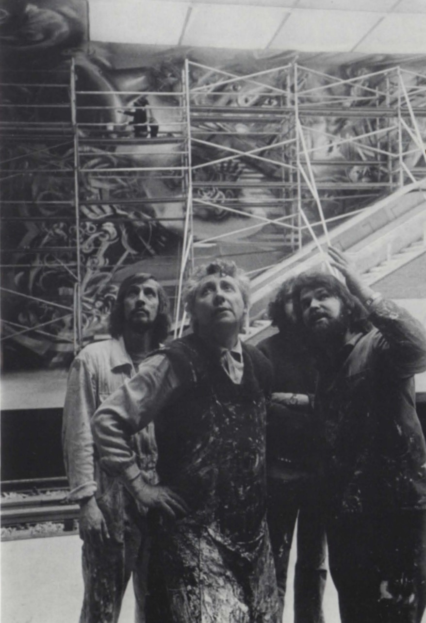 Roger Somville et deux jeunes peintres en bleu de travail devant le mural Hankar en chantier, échafaudages tubulaires.